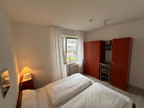 a small bedroom with a bed and a window at Sandbank in Langeoog