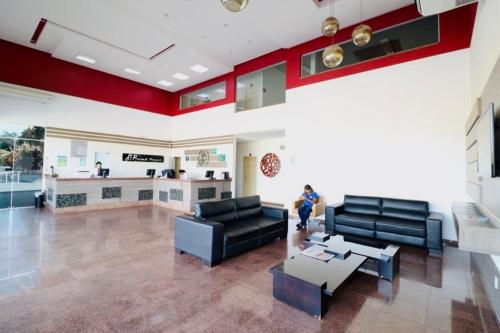 a living room with two black couches and a kitchen at OFERTA - Fiori DiRoma Caldas Novas - Térreo - Parque Aquático 24h in Caldas Novas