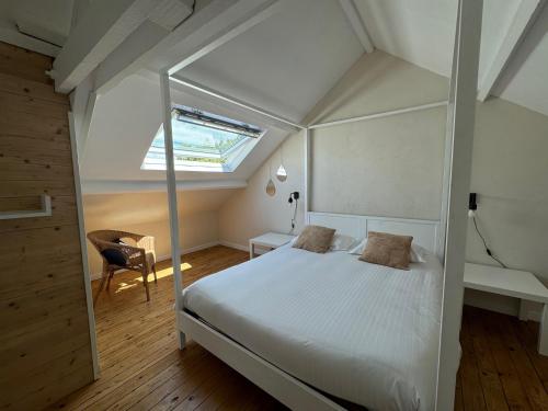 a bedroom with a canopy bed in a attic at Apparthôtel Mont Saint Michel - Résidence Fleurdumont in Beauvoir