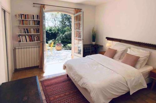 - une chambre avec un lit et une porte donnant sur une terrasse dans l'établissement Villa provençale atypique à 5 m à pied de la plage, à Saint-Raphaël
