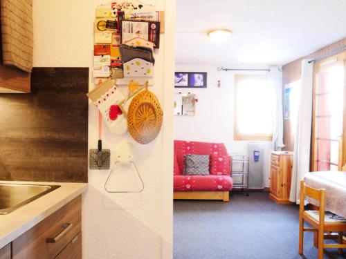 Il comprend une cuisine et un salon avec un canapé rouge. dans l'établissement Résidence LA PORTE DE MONTCHAVIN - Studio pour 3 Personnes MAE-9904, à Aime La Plagne