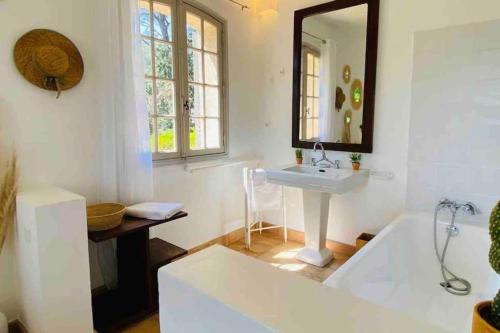 une salle de bain avec un lavabo et une baignoire dans l'établissement Villa provençale atypique à 5 m à pied de la plage, à Saint-Raphaël
