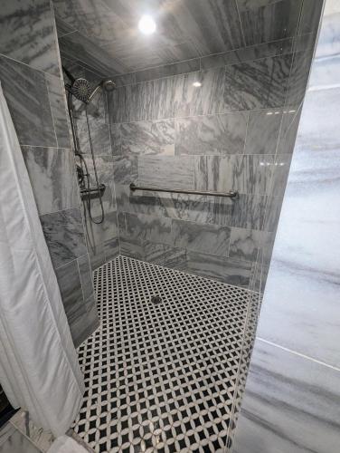 a bathroom with a shower with a black and white tiles at The Esplanade Guesthouse Mansion in New Orleans