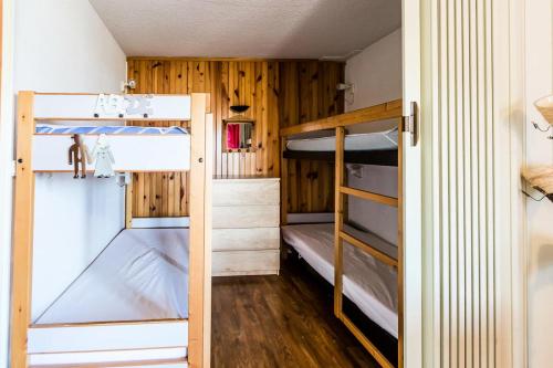Ce lit se trouve dans un dortoir doté de 2 lits superposés et de murs en bois. dans l'établissement Résidence LES COTES - Studio pour 4 Personnes MAE-6724, à Aime La Plagne