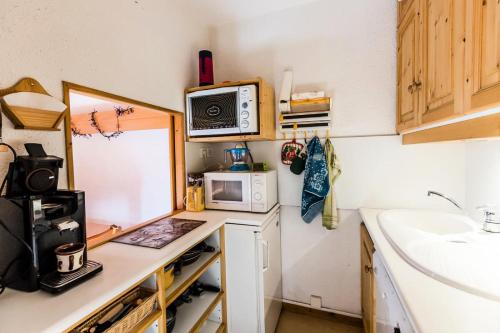 une petite cuisine avec un évier et un micro-ondes dans l'établissement Résidence LA ROCHETTE - 2 Pièces pour 5 Personnes MAE-1404, à Aime La Plagne