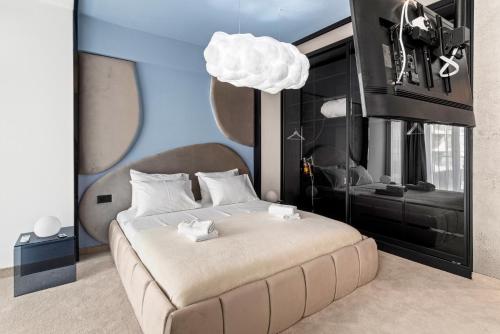 a bedroom with a large white bed with a pendantperture at 5 Senses by Jorge in Infinity Pool & Spa Resort in Mamaia Sat/Năvodari