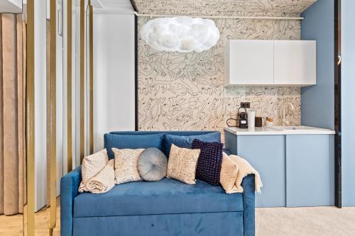 un canapé bleu avec des coussins dans un salon dans l'établissement 5 Senses by Jorge - Infinity Pool & Spa Resort, à Mamaia Nord – Năvodari