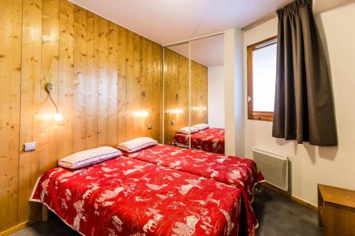 une chambre avec un lit rouge et un miroir dans l'établissement Résidence LES 3 GLACIERS - 4 Pièces pour 8 Personnes MAE-0074, à Aime La Plagne