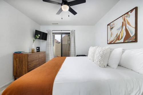 a bedroom with a white bed and a ceiling fan at Stylish Townhome on Golf Course Red Rock View in Sedona