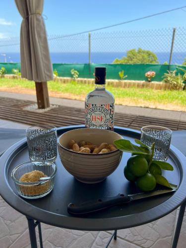 a table with a bowl of nuts and a bottle of alcohol at Casa François - Terrasse vue mer & clim in Le Carbet