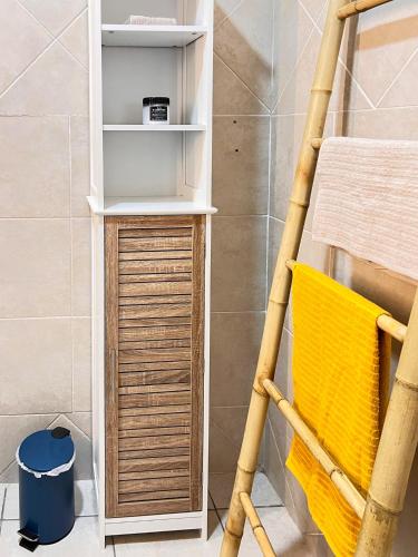 a bathroom with a wooden shelf and a yellow chair at Casa François - Terrasse vue mer & clim in Le Carbet