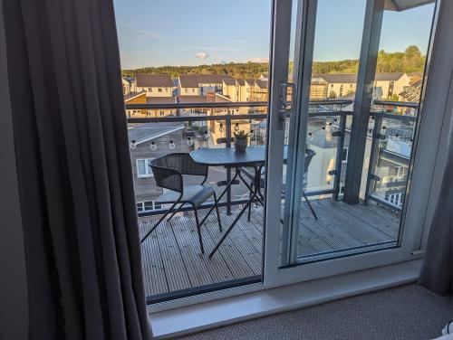 a balcony with a table and a view of a city at Two Bedroom Duplex Apartment in Swansea
