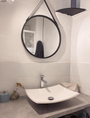 une salle de bain avec un lavabo blanc et un miroir dans l'établissement La petite Maison Rouge, à Portel-des-Corbières