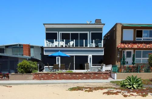 a house with a patio with a blue umbrella at 1023 E Balboa B in Newport Beach