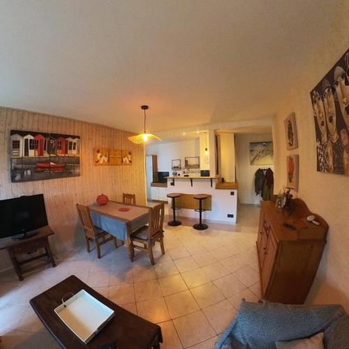 un salon avec une table et une cuisine dans l'établissement Au Jardin, à La Rochelle