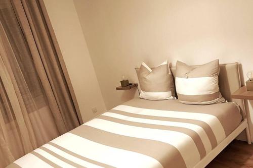 une chambre avec un lit avec des oreillers et une fenêtre dans l'établissement Les Nuages de Sablon, à Clermont-Ferrand