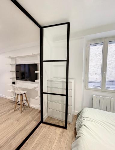 - un miroir dans une chambre avec un lit et un bureau dans l'établissement Chez Julie, à Fontainebleau