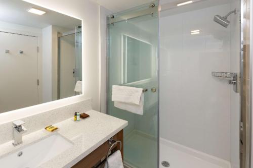 a bathroom with a shower and a sink and a mirror at Executive Residency by Best Western Calgary City View North in Calgary