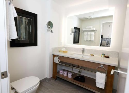 a bathroom with a sink and a toilet and a mirror at Executive Residency by Best Western Calgary City View North in Calgary