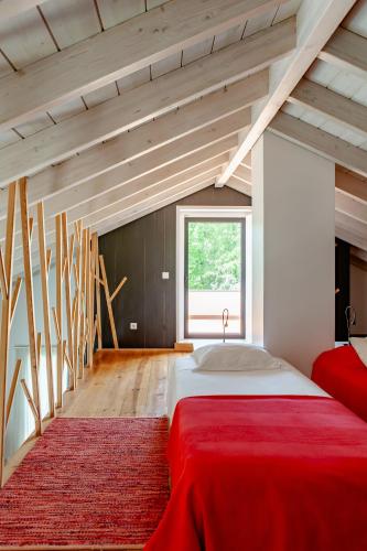 a bedroom with a red bed and a window at Casas da Fontanheira in Marvão