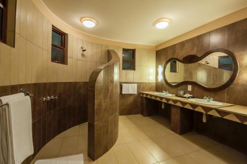 a bathroom with two sinks and a mirror at Lake Nakuru Sopa Lodge in Nakuru