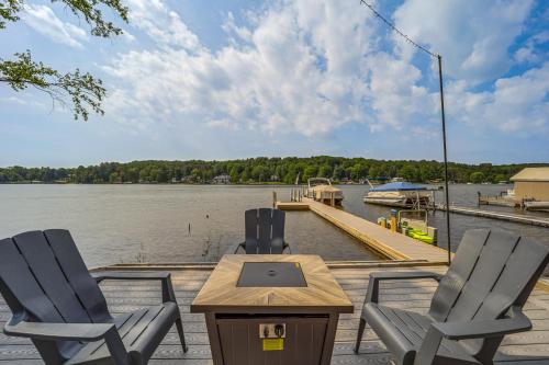 two chairs and a table on a dock with a boat at Clam Lake Vacation Rental with Deck and Shared Dock! in Bellaire