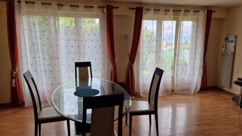 une salle à manger avec une table et des chaises en verre dans l'établissement Chambre Jardin 1, à Vaujours