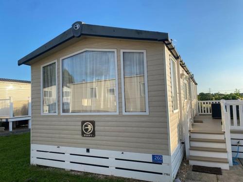 a tiny house with a staircase in a yard at Holiday home in Furzehill in Wimborne Minster