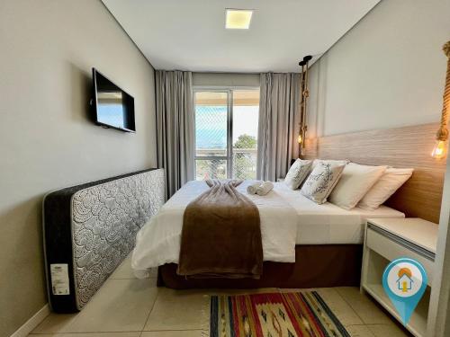 a bedroom with a large bed with a window at N1204 Perfeito apto para férias e Beto Carrero! in Penha