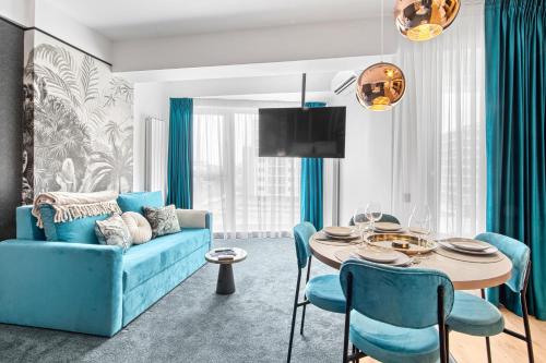 a living room with a blue couch and a table at 5 Senses by Jorge in Infinity Pool & Spa Resort in Mamaia Sat/Năvodari