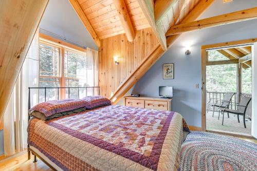 una camera da letto con un letto grande e un balcone di Lakefront Corinth Log Home Private Dock, Fire Pit a Lake Luzerne