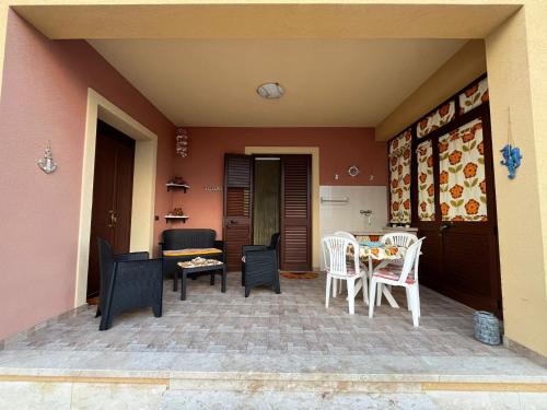 a patio with chairs and a table and a couch at Casa Salinella in Torre Nubia