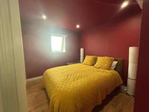 a bedroom with a yellow bed and a window at Gîte au haras La Belle in Émanville