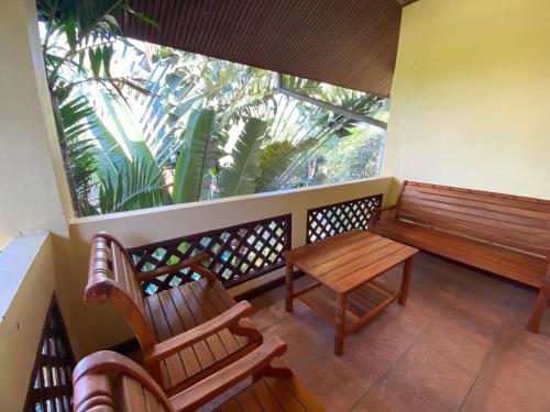 a balcony with a wooden bench and a table at Samui Green Life in Bophut 