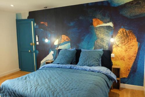 a bedroom with a bed with a blue wall at Gîte au haras La Belle in Émanville