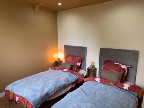 two beds sitting next to each other in a room at Gîte au haras La Belle in Émanville