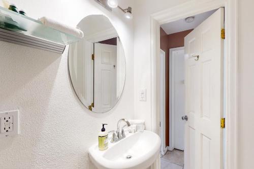 Un baño blanco con lavabo y espejo. en Mountainside, en Vail