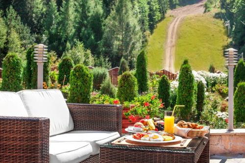 a table with a plate of food and a glass of orange juice at Hotel Yastrebets Wellness & Spa in Borovets