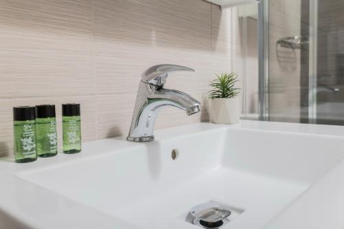 a bathroom sink with a faucet and two soap bottles at Sea View Apollo Apartments & Studios in Afytos in Afitos