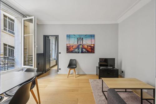un salon avec une table et une chaise dans l'établissement Terne Maillot - Gaston Bertandeau 1dbr, à Paris