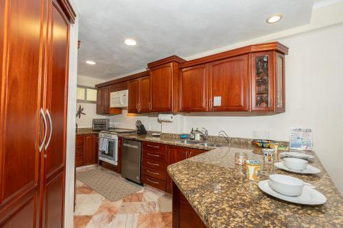 a kitchen with wooden cabinets and granite counter tops at Ocean Front, With Pool, 6 People, Quinta del Mar PH502 in Bucerías
