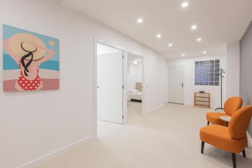 a living room with an orange chair and a painting at Amplio Apartamento Cerca Centro Histórico y Turia 5pax 2 Bath in Valencia