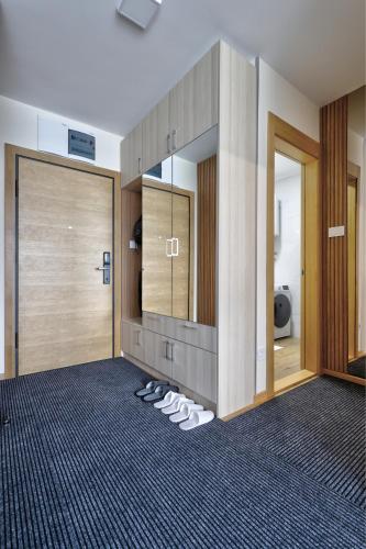 a bathroom with a pair of shoes in front of a mirror at Lux Mila with Free Private parking in Novi Sad