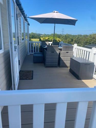 a porch with chairs and an umbrella on a house at Holiday home in Furzehill in Wimborne Minster