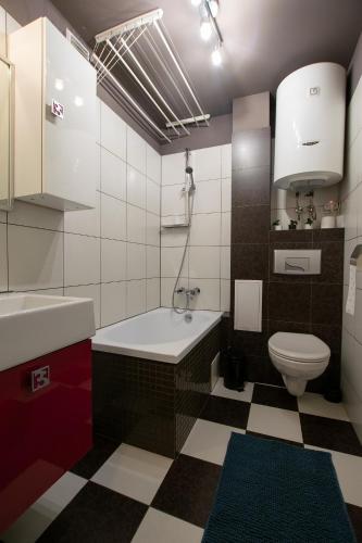 a bathroom with a tub and a toilet and a sink at Apartament Na Parterze in Lesko