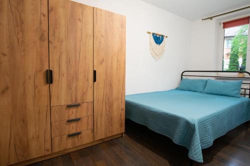 a bedroom with a bed and a wooden cabinet at Apartament Na Parterze in Lesko