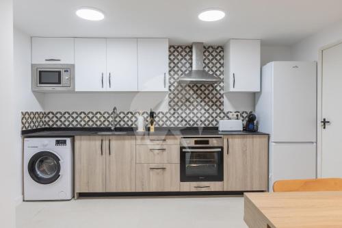 a kitchen with white cabinets and a washer and dryer at Amplio Apartamento Cerca Centro Histórico y Turia 5pax 2 Bath in Valencia