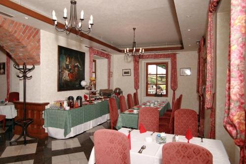 a dining room with two tables and chairs in a restaurant at Golf Resort Hotel Konopiště in Benešov