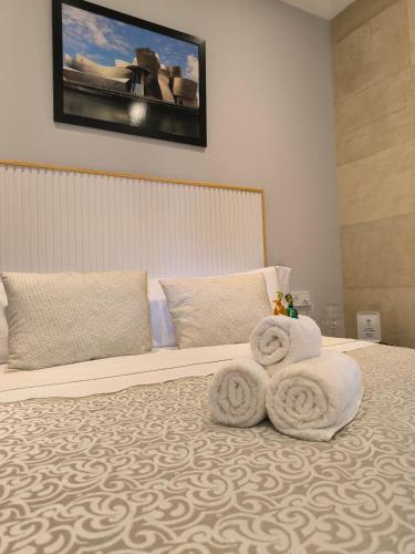 a bedroom with a bed with towels on it at HABITACION CON HERMOSAS VISTAS A BILBAO in Bilbao