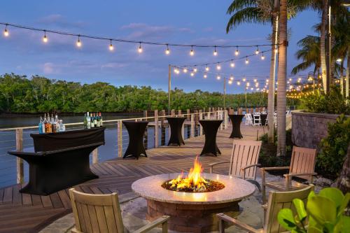 a fire pit on a deck with chairs and lights at Hyatt House Naples 5th Avenue in Naples